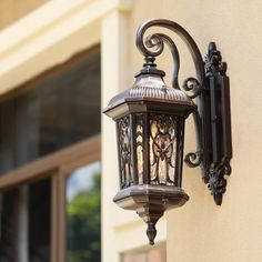 an old fashioned street light on the side of a building