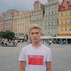 a young man standing in front of some buildings