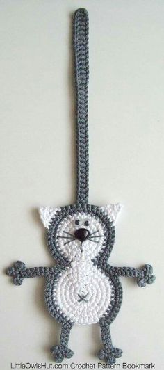 a crocheted cat ornament hanging from a hook on a wall in the shape of a key chain