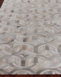 an area rug is shown on the floor with wood floors in the background and a wooden table