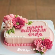 a pink birthday cake with flowers on it