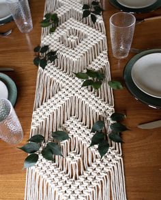 the table runner is decorated with greenery