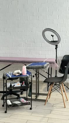 a table with chairs and a camera in front of a white brick wall behind it