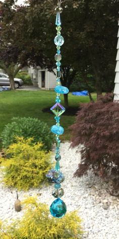 a glass wind chime hanging from the side of a house