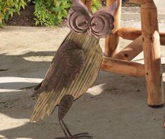 an owl statue sitting on top of a wooden bench