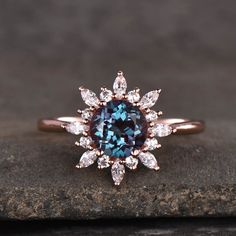 a blue diamond ring on top of a rock with white diamonds around the band and center stone