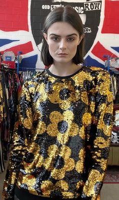 Golden hour is every hour in the Any Old Iron Mini Quant Sweatshirt! This full sequin sweatshirt is sure to brighten up your day with a gold and black floral design from the back to the front. The golden flowers can be flipped to a beautiful black rendition with just the swipe of a hand. This sweatshirt, also, features ribbed cotton along the sleeves, neckline, and hemline to keep you warm on those cooler days. The interior lining is composed out of silky satin for optimal ventilation too. Needl Sequined Sweatshirt, Kate Bosworth, Golden Flower, Elton John, Cardi B, Golden Hour, Black Floral, Color Change, Looks Great