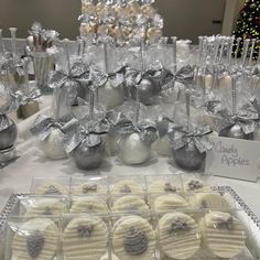 there are many desserts on the table with silver and white decorations around them for sale