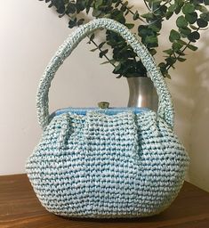 "1950s 1960s Dayne Taylor Pale Blue Raffia Purse, Vintage Top Handle Handbag, Mid Century Accessory Pretty pale blue raffia purse made by Dayne Taylor in the 1950s 1960s that features: Double handle straps. Gold tone metal hardware with a round thumb lift clasp closure that works well and closes tightly. Opens to a pale blue fabric lining with one interior side metal zippered pocket. Dayne Taylor Made In Japan label attached. There are protective feet on the bottom of the bag. Beautiful vintage Blue Retro Evening Bag, Retro Blue Evening Bags, Retro Handmade Bags For Vintage Fashion, Vintage Crochet Beach Bag, Vintage Woven Handheld Bag, Vintage Handheld Woven Bag, Retro Handmade Blue Bags, Retro Blue Handmade Bags, Raffia Purse