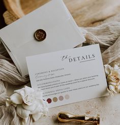 a close up of a piece of paper with a pen and flower on it next to an envelope