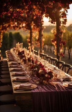 a long table is set with place settings and candles for an elegant dinner party in the evening