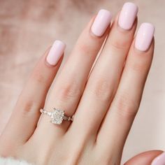 a woman's hand with pink manicured nails and a ring on her finger