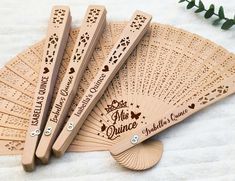 four wooden fans with engraved names on them