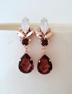 a pair of earrings with red and white stones