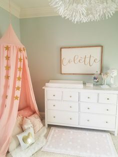 a baby's room with a teepee tent, dressers and bedding