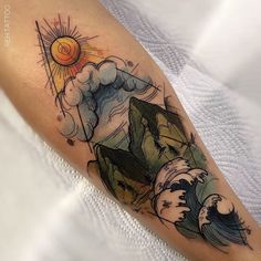 a person with a tattoo on their arm that has an image of a mountain and waves