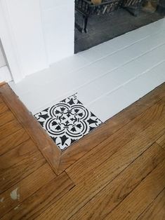 a black and white tile floor in front of a fireplace