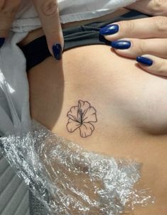 a woman's stomach with a flower tattoo on it