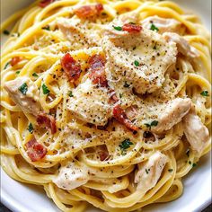 a white plate topped with pasta covered in chicken and sauce