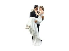 a figurine of a bride and groom holding each other on a white background