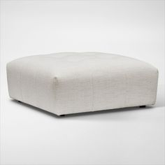 a white ottoman sitting on top of a floor