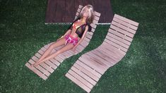 a barbie doll laying on top of a wooden mat