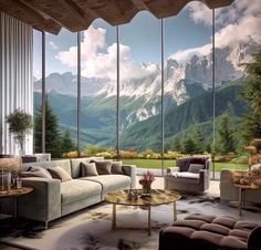 a living room filled with furniture and large windows overlooking the mountain range in the distance