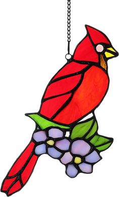 a stained glass cardinal sitting on a branch with flowers hanging from it's side