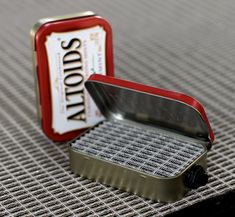 an empty tin can sitting on top of a table next to a small metal container