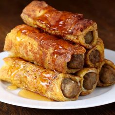 three sausage rolls stacked on top of each other with sauce drizzled over them