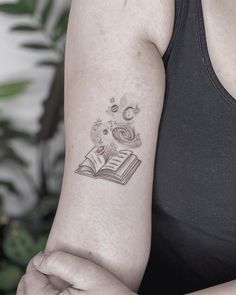 a woman with a book tattoo on her arm