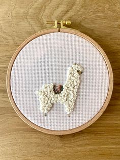 a cross stitch pattern with a white dog on it's face in the hoop