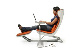 a woman sitting in an orange and white chair using a laptop