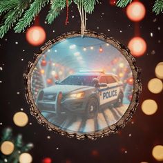 a police car ornament hanging from a christmas tree