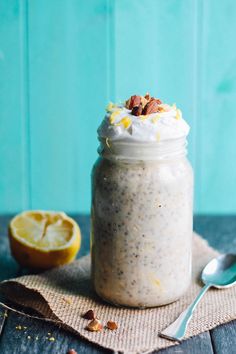 a glass jar filled with oatmeal sitting on top of a table next to a lemon