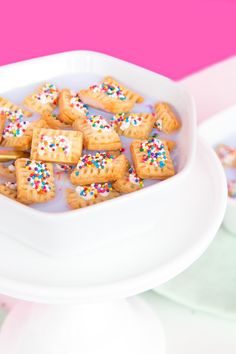 a bowl filled with cookies and sprinkles on top of a white plate