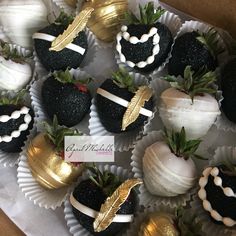 chocolate covered strawberries with gold leaf decorations and white frosting in a cardboard box