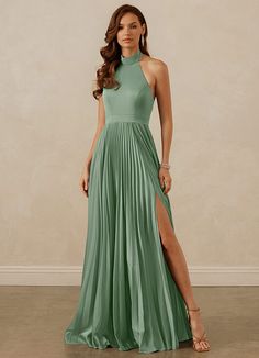 a woman in a long green dress posing for the camera with her legs slited