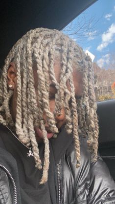 a man with dreadlocks sitting in a car