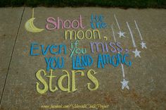 a sidewalk with chalk writing on it that says shoot for the moon even you miss, you land among stars