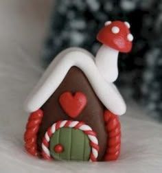 a small gingerbread house with candy canes on the outside and a mushroom on top