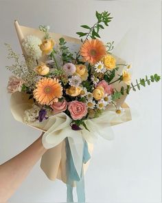 a bouquet of flowers is being held by someone's hand