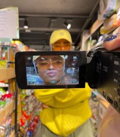 a person holding up a camera to take a selfie in a grocery store aisle