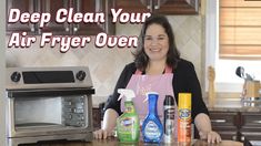 a woman standing in front of an oven with cleaning products on the counter next to her