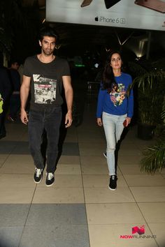 the man and woman are walking through an airport