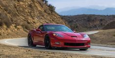 a red sports car driving down a winding road