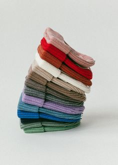 a stack of folded sweaters sitting on top of each other in different colors and sizes