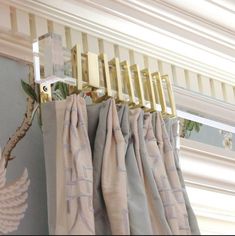 curtains are hanging on the rod in front of a window with gold hardware and metal bars