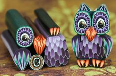 two purple and orange owls are sitting next to each other on a brown tablecloth