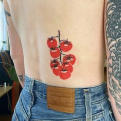 a person with tattoos on their stomach and cherry tomatoes painted on the back of their body